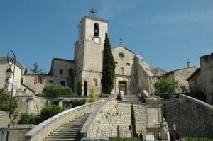 un vecchio edificio con torre dell'orologio e scale di Beauregard, votre maison en Provence a Orgon