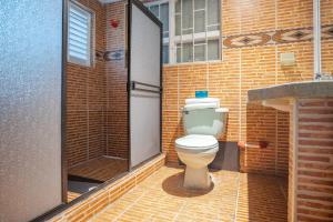 a bathroom with a toilet in a brick building at Hotel Bogota Home in Bogotá
