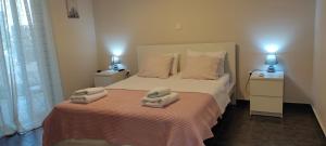a bedroom with a bed with towels on it at Double M near Athens Airport in Markopoulo
