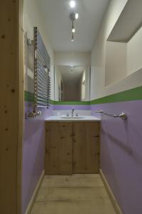 ein Bad mit einem Waschbecken und einem Spiegel in der Unterkunft Alte Scheune - Samedan in Samedan