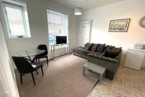 a living room with a couch and a table at Arthur Apartment in Hawick