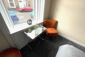 a bedroom with a desk and a chair and a window at Arthur Apartment in Hawick
