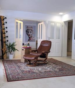 a brown chair sitting on a rug in a living room at Club Dres in Bockau