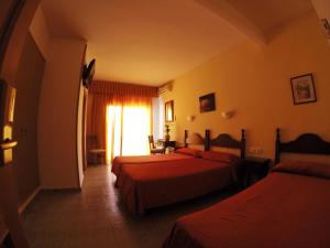 pokój hotelowy z dwoma łóżkami i oknem w obiekcie Hotel Carmen Teresa w mieście Torremolinos