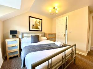 a bedroom with two beds and a chandelier at Aylesbury Contractor & Staycation Home in Aylesbury