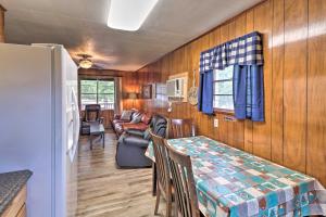 a living room with a table and a couch at Devils Fork Resort Cabin with Designated Boat Slip! in Fairfield Bay
