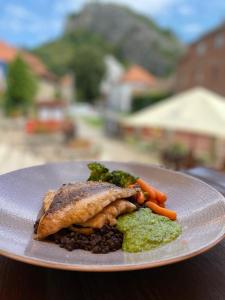 a plate of food with beans and vegetables on a table at Hotel Obecná Škola in Svatý Jan pod Skalou