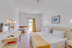 um quarto de hotel com uma cama e um sofá em Natur Garden Hotel em Bitez