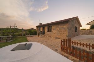 un edificio de piedra con una mesa delante en A Casa da Charca - Casa rural con jardín en Pontevedra