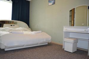 a bedroom with a white bed and a mirror at Zajazd Maxim in Żywiec