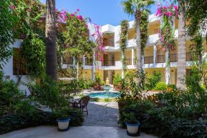 Ein Innenhof eines Hotels mit Swimmingpool und Bäumen in der Unterkunft Natur Garden Hotel in Bitez