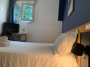 1 dormitorio con 1 cama con sábanas blancas y ventana en Hôtel Montilleul - Villa Primrose, en Pau