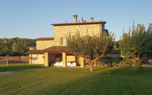 um grande edifício de tijolos com um campo de relva em frente em Agriturismo Villa al piano em Todi