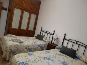a bedroom with two beds with blue and white sheets at El Herrador in Nájera