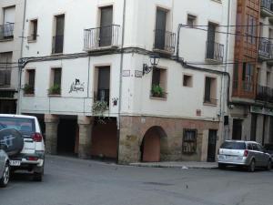 een wit gebouw met auto's ervoor geparkeerd bij El Herrador in Nájera