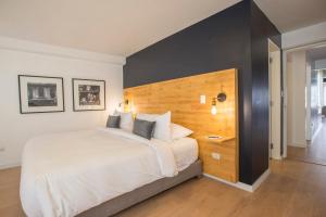 a bedroom with a large bed with a wooden headboard at Natural 3BR in Barranco in Lima
