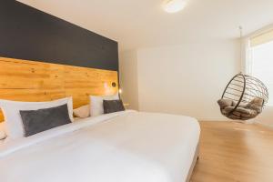 a bedroom with a large white bed with a wooden headboard at Natural 3BR in Barranco in Lima