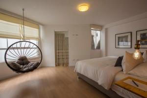 a bedroom with a bed and a hanging chair at Natural 3BR in Barranco in Lima
