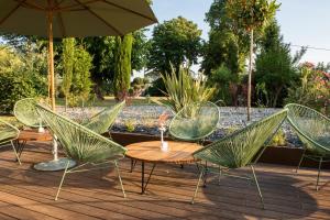 a group of chairs and tables with an umbrella at Résidence de Diane - Toulouse in Toulouse