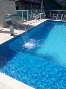 une fontaine dans la piscine dans l'établissement Canto Verde Aptos II, à Caraguatatuba