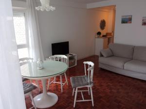 a living room with a table and chairs and a couch at Estudio con vistas al mar en Baiona in Baiona