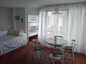 a bedroom with a table and chairs and a bed at Estudio con vistas al mar en Baiona in Baiona