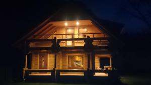 une maison la nuit avec les lumières allumées dans l'établissement Guļbūve ar saunu, kamīnu, à Saulkrasti