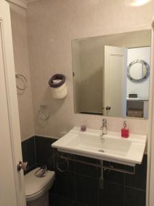 a bathroom with a sink and a toilet and a mirror at Estudio con vistas al mar en Baiona in Baiona
