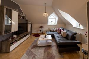 ein Wohnzimmer mit einem Sofa und einem TV in der Unterkunft Apartment Ella in Klagenfurt am Wörthersee