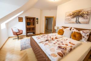 a bedroom with a large bed and a chair at Apartment Ella in Klagenfurt