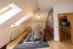 ein Esszimmer mit einem Tisch, Stühlen und einem Fenster in der Unterkunft Apartment Ella in Klagenfurt am Wörthersee
