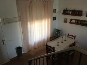 uma mesa e cadeiras num quarto com uma janela em Los Candiles em Conil de la Frontera