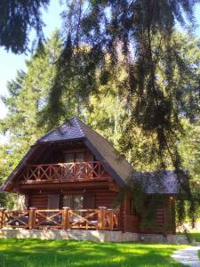 uma cabana na floresta com uma árvore em Zlatiborske brvnare em Zlatibor