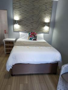 a bedroom with a large bed with two pillows at Busis guesthouse in Durban