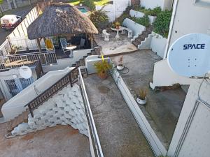 an aerial view of a patio with a thatch roof at Busis guesthouse in Durban