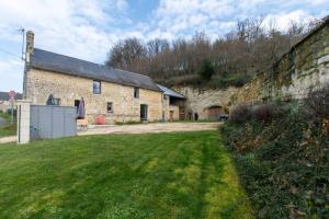 un antiguo edificio de piedra con un patio de césped delante de él en gite en Touraine, en Thizay