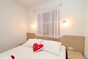 łóżko z czerwonym sercem na poduszce w obiekcie Seaside Apartments Hrkać w Orebiciu