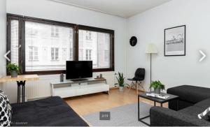 a living room with a couch and a flat screen tv at Scandinavian Home in heart of Helsinki 26 in Helsinki