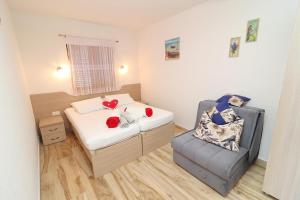 niewielka sypialnia z łóżkiem i krzesłem w obiekcie Seaside Apartments Hrkać w Orebiciu