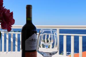 butelkę wina siedzącą obok szklanki w obiekcie Seaside Apartments Hrkać w Orebiciu