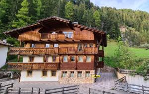 a large wooden building with a balcony at Appartamento Cesa Lamar in Canazei