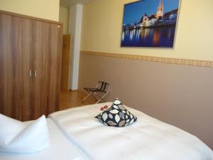 a bedroom with a bed with a pillow on it at Stadthotel Regensburg in Regensburg