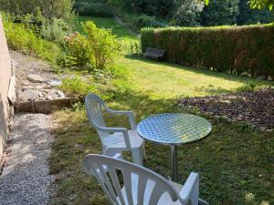 einen Tisch und zwei Stühle sowie einen Tisch und Stühle in der Unterkunft Joli Studio près des Bains de Lavey in Savatan
