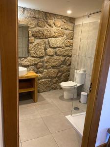a stone bathroom with a toilet and a sink at Quinta do Pinheiro in Guimarães +43 photos