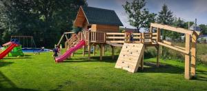 a group of children playing in a park with a playground at Wynajem pokoi in Czarny Dunajec