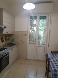 cocina con puerta blanca y mesa en casa vacanze Lida, en Marina di Carrara
