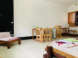 een kamer met 2 bedden en een tafel en stoelen bij Pedra de Rala in Porto Novo