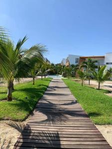 a wooden pathway with palm trees on a beach at Departamento Las Palmeras de Bocapan 308 in Tumbes