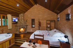 1 dormitorio con 1 cama, chimenea y bañera en Pousada Vista Bonita, en Visconde De Maua