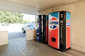 two pepsi machines are sitting in a building at Town and Country INN in Rogers